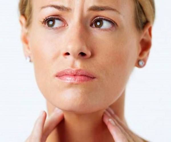 Женщина держится за горло